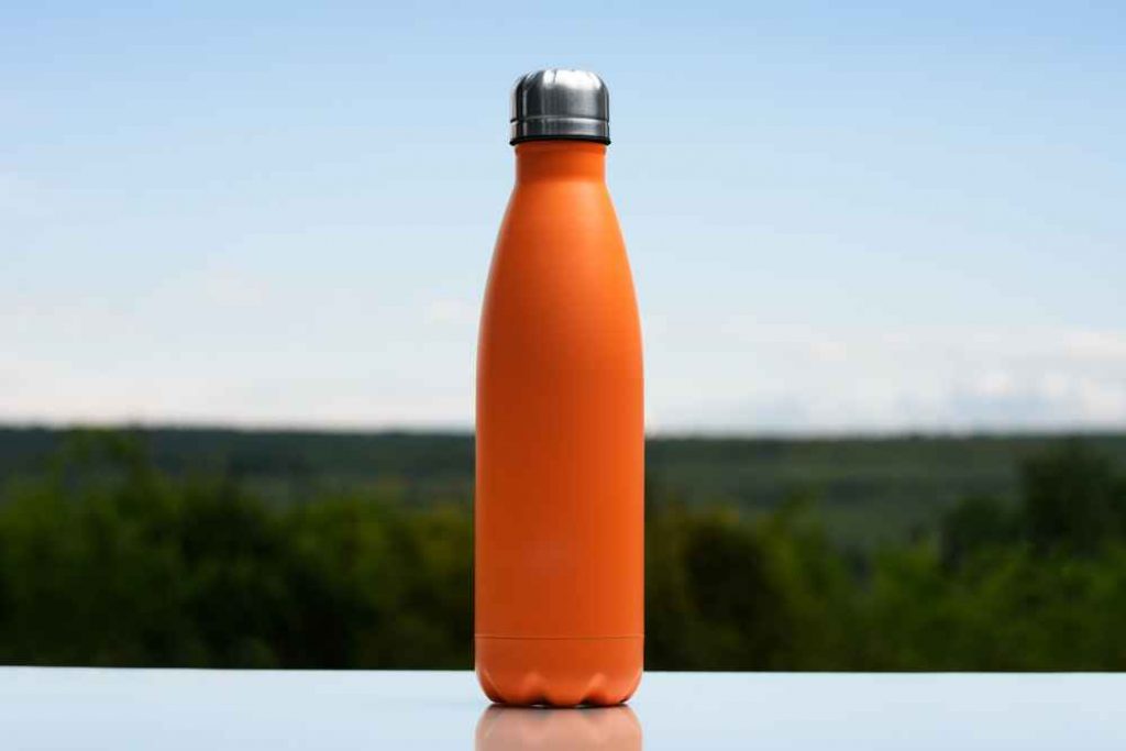 An orange water bottle under blue sky